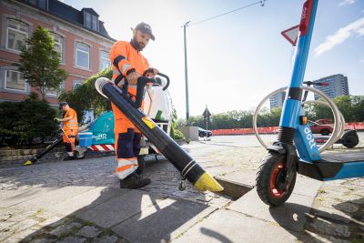 Deux hommes aspirent les déchets dans la rue avec l'aspirateur Glutton